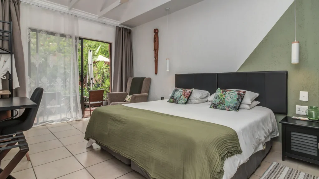 Buffalo Premium room with double bed, armchair and doors to the garden